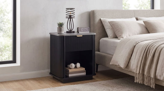 Tura black bedside table with drawer front view showing fluted wave-detail drawer and open lower shelf, plain white background