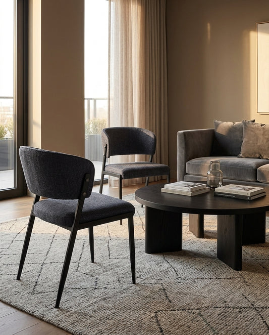 Harper charcoal dining chair set of two at a round dark dining table with warm ambient lighting and gold floor lamp