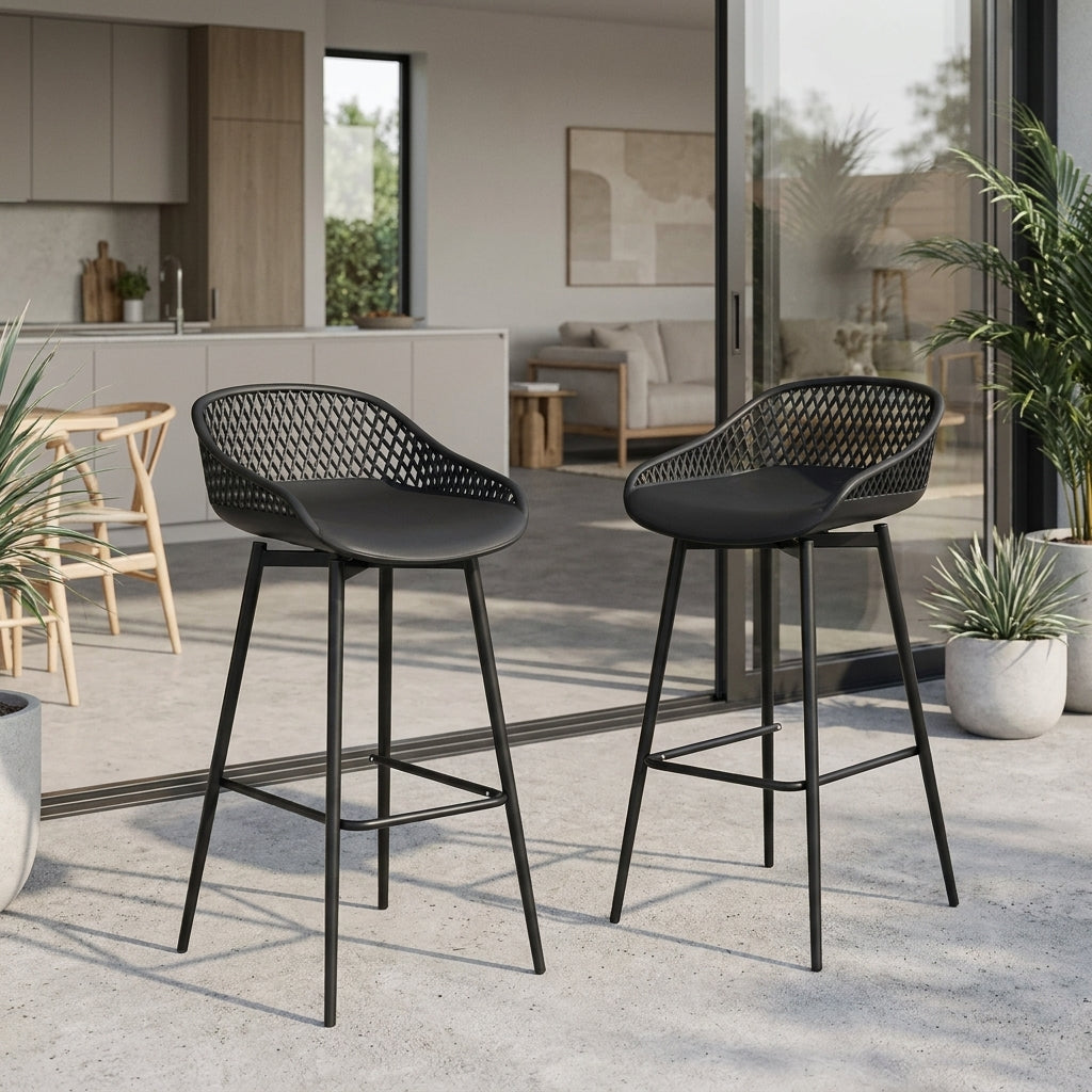 Two black bar stools with woven seats in a modern outdoor setting.