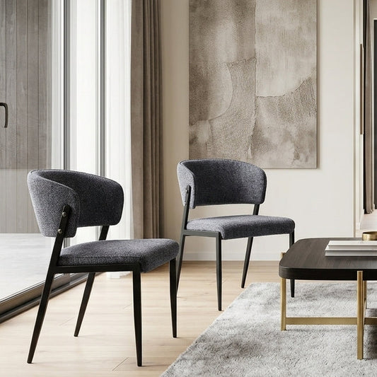 Harper charcoal dining chair set of two in a warm neutral room with textured wall art and small black side table