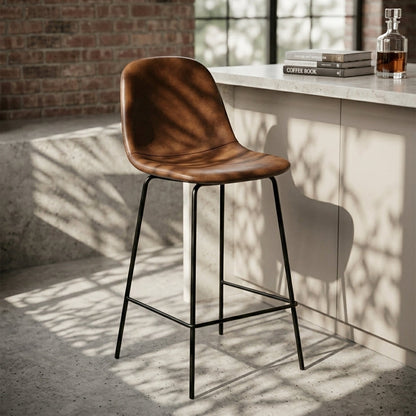 Marlo cognac brown leather bar stools set of two at a concrete kitchen island, slim black powder-coated steel frame with integrated footrest