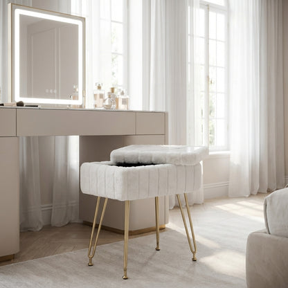white vanity table with mirror and stool in a bright room with large windows.