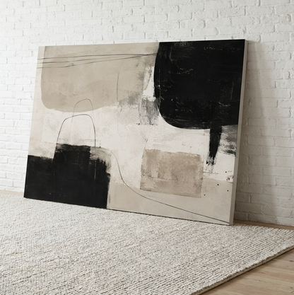 Align neutral abstract canvas wall art in sand, cream and black leaning on a wall