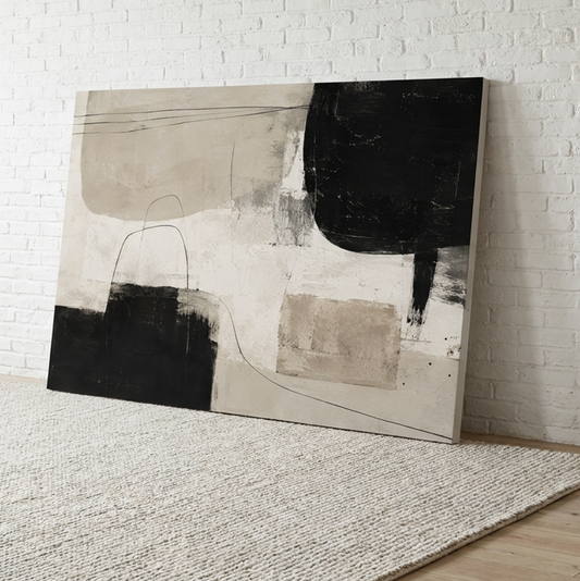Align neutral abstract canvas wall art in sand, cream and black leaning on a wall