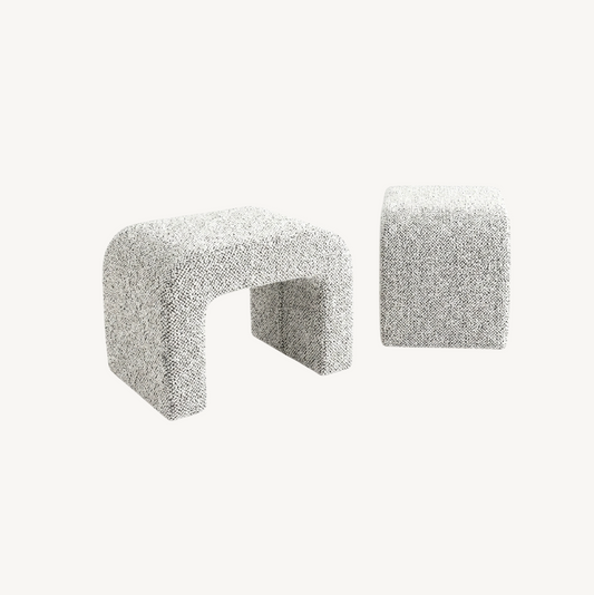 Hendrix arched textured ottoman in frosted stone boucle, sculptural arch cut-out form styled at the end of a bed in a neutral bedroom