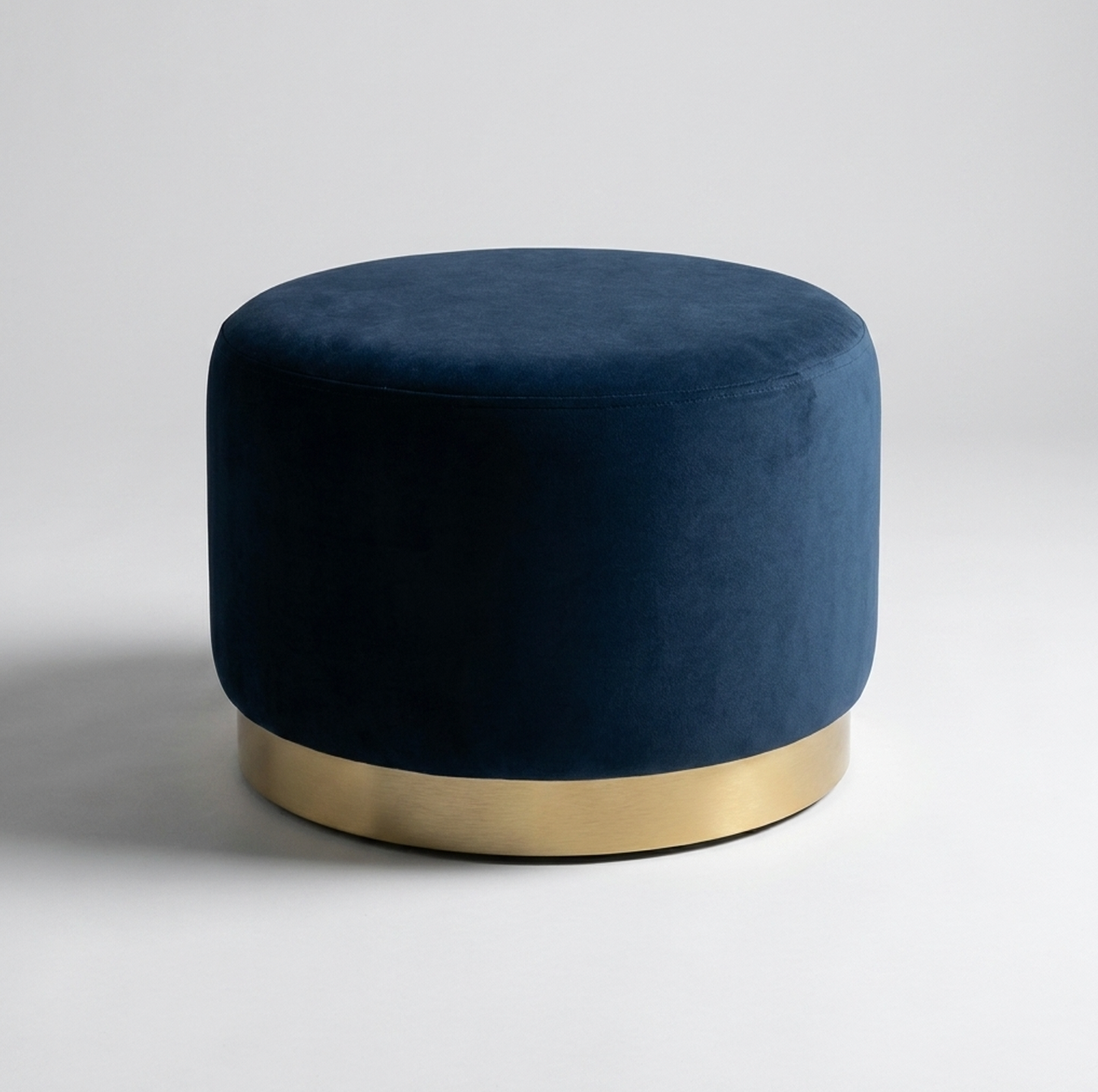 Interior Ave ocean ottoman with a gold base on a light gray background