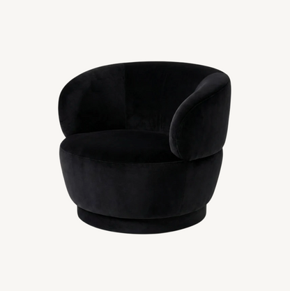 Luna swivel armchair in black velvet with sculptural curved form and swivel base, styled in a contemporary interior