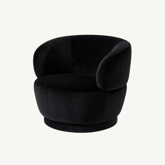 Luna swivel armchair in black velvet with sculptural curved form and swivel base, styled in a contemporary interior