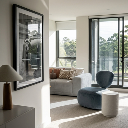 Muse fossil side table shown in two styled interiors — beside a navy accent chair and beside a warm neutral sofa