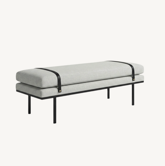 Porter bench in light grey with slim black metal frame, low-profile elongated silhouette styled at the end of a bed in a bright minimal bedroom