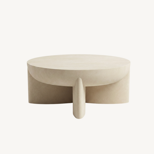 Zelda sculptural stone coffee table in sand textured finish, white background product shot showing bowl-style top and three angled architectural legs